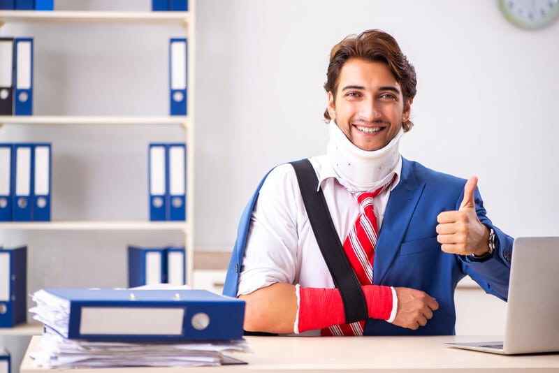 Employee injured workers compensation return to work smiling at desk