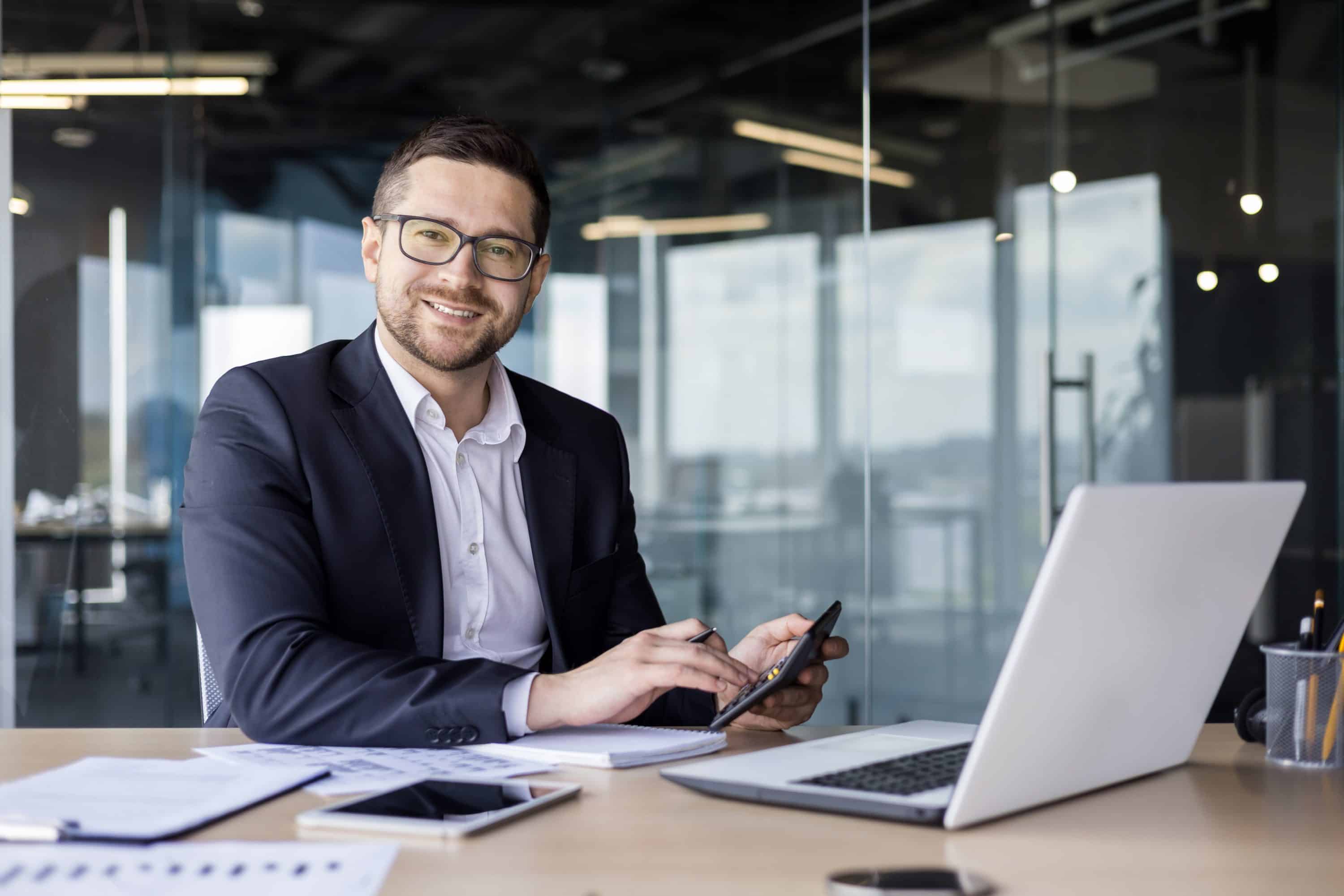 male worker smiling at camera doing wages pays calculating