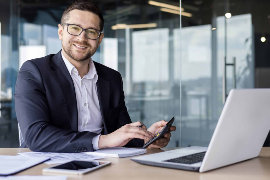 male worker smiling at camera doing wages pays calculating
